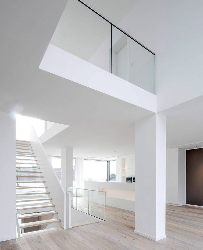 This is an example of a large contemporary wood straight staircase in Dusseldorf with open risers.