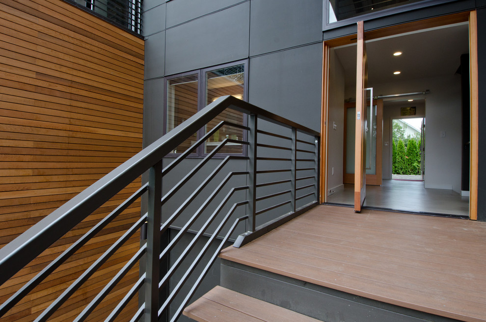Photo of a mid-sized modern front door in Seattle with white walls, concrete floors, a pivot front door and a light wood front door.