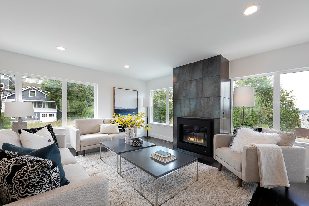Design ideas for a contemporary living room in Seattle with white walls, dark hardwood floors, a standard fireplace, a tile fireplace surround and brown floor.
