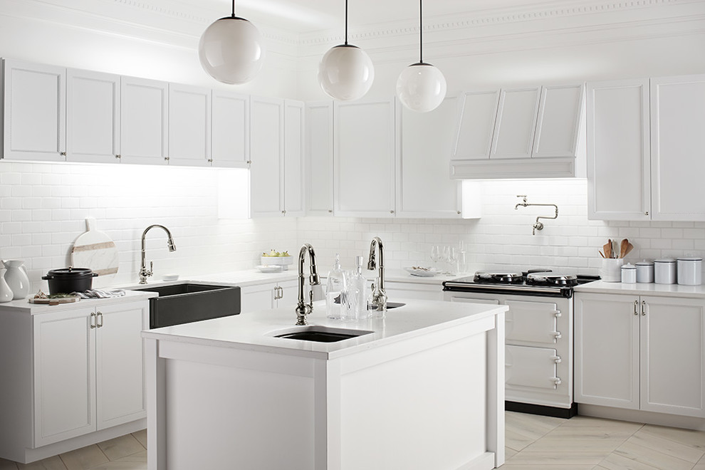 Design ideas for a large modern l-shaped kitchen in Houston with a farmhouse sink, recessed-panel cabinets, white cabinets, solid surface benchtops, white splashback, subway tile splashback, panelled appliances, porcelain floors, with island and beige floor.