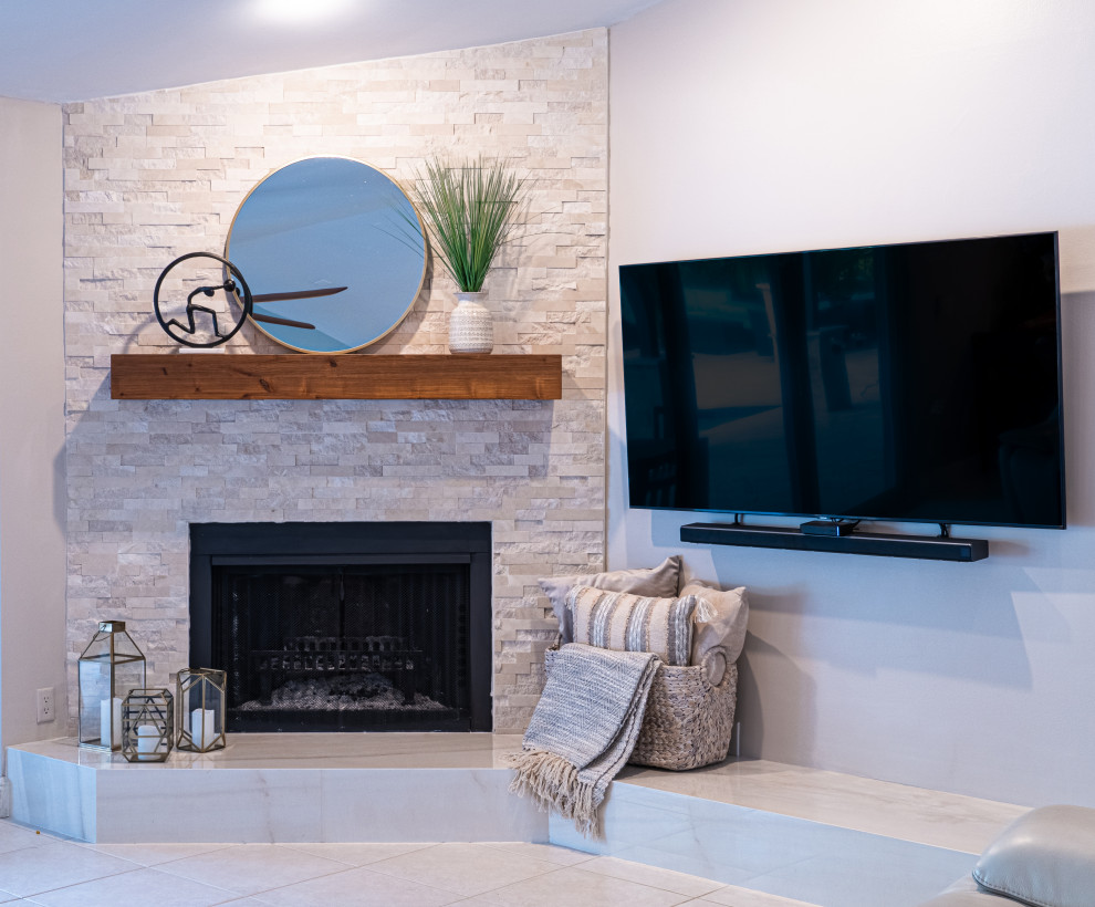 Mittelgroßes, Offenes Maritimes Wohnzimmer mit beiger Wandfarbe, Eckkamin, Kaminumrandung aus Stein, TV-Wand und beigem Boden in Miami