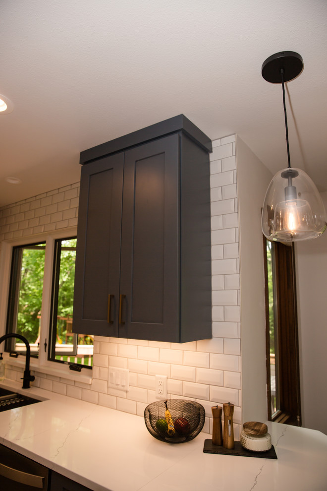 Eat-in kitchen - mid-sized transitional galley medium tone wood floor and brown floor eat-in kitchen idea with an undermount sink, shaker cabinets, white cabinets, solid surface countertops, white backsplash, ceramic backsplash, stainless steel appliances, a peninsula and white countertops