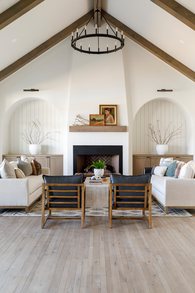 Living room - mid-sized country medium tone wood floor, vaulted ceiling and shiplap wall living room idea in Boise with white walls, a standard fireplace and a plaster fireplace