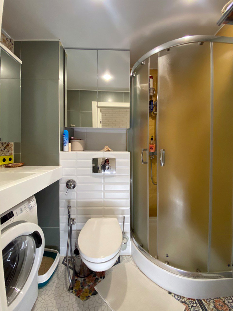 Стильный дизайн: маленькая главная ванная комната в современном стиле с плоскими фасадами, белыми фасадами, угловым душем, инсталляцией, разноцветной плиткой, керамогранитной плиткой, зелеными стенами, полом из керамической плитки, подвесной раковиной, белым полом, душем с раздвижными дверями, белой столешницей, тумбой под одну раковину, подвесной тумбой и гигиеническим душем для на участке и в саду - последний тренд