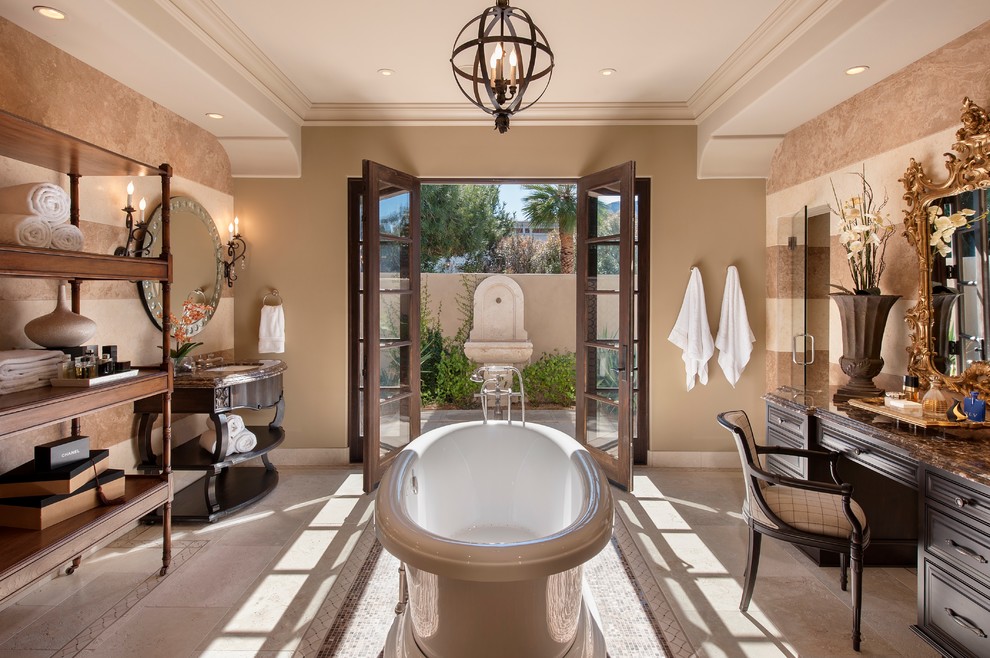 This is an example of a large traditional master bathroom in Phoenix with a freestanding tub, a console sink, dark wood cabinets, an alcove shower, stone tile, beige walls, limestone floors, granite benchtops, beige floor and beaded inset cabinets.
