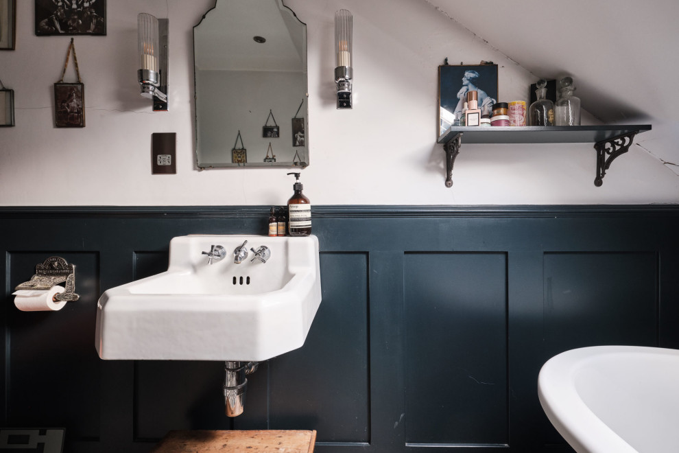 Design ideas for a medium sized bohemian cream and black shower room bathroom in London with white cabinets, a claw-foot bath, a shower/bath combination, a two-piece toilet, white walls, ceramic flooring, a wall-mounted sink, blue floors, feature lighting, a single sink, a floating vanity unit and panelled walls.