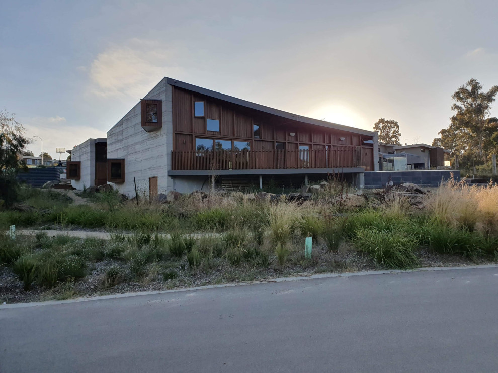 Industrial Einfamilienhaus mit Betonfassade, grauer Fassadenfarbe, grauem Dach und Wandpaneelen in Melbourne