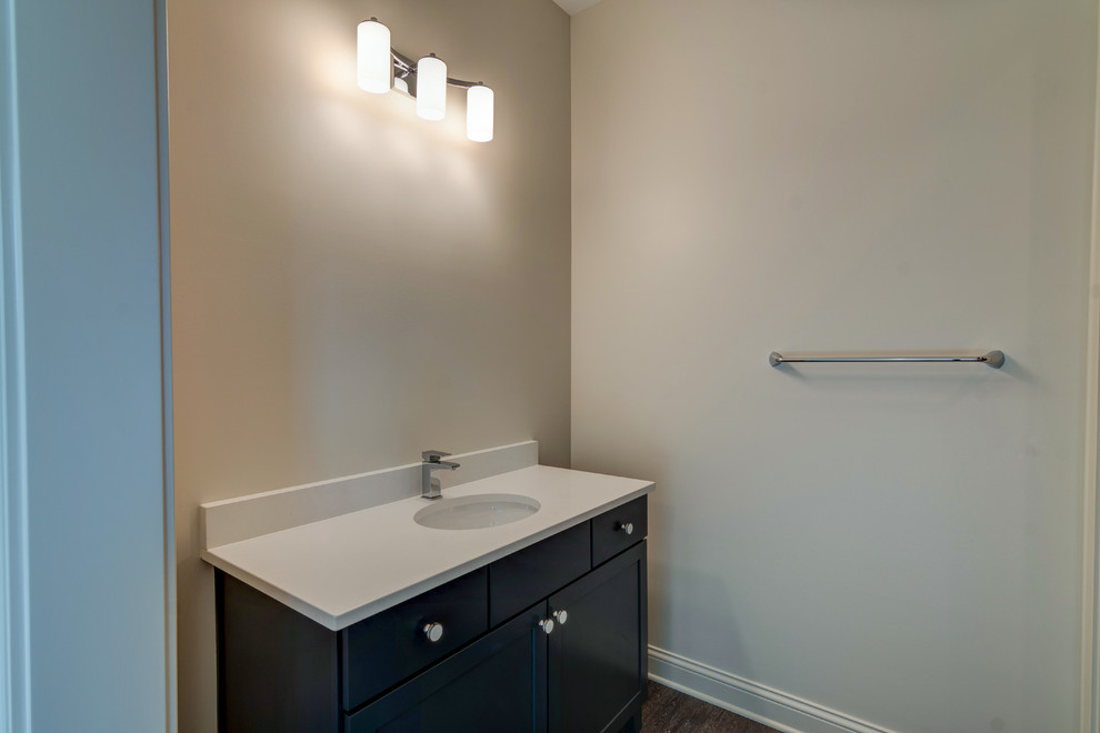 Photo of a large country 3/4 bathroom in Indianapolis with shaker cabinets, black cabinets, a curbless shower, a one-piece toilet, brown tile, ceramic tile, white walls, ceramic floors, a drop-in sink, grey floor and a sliding shower screen.