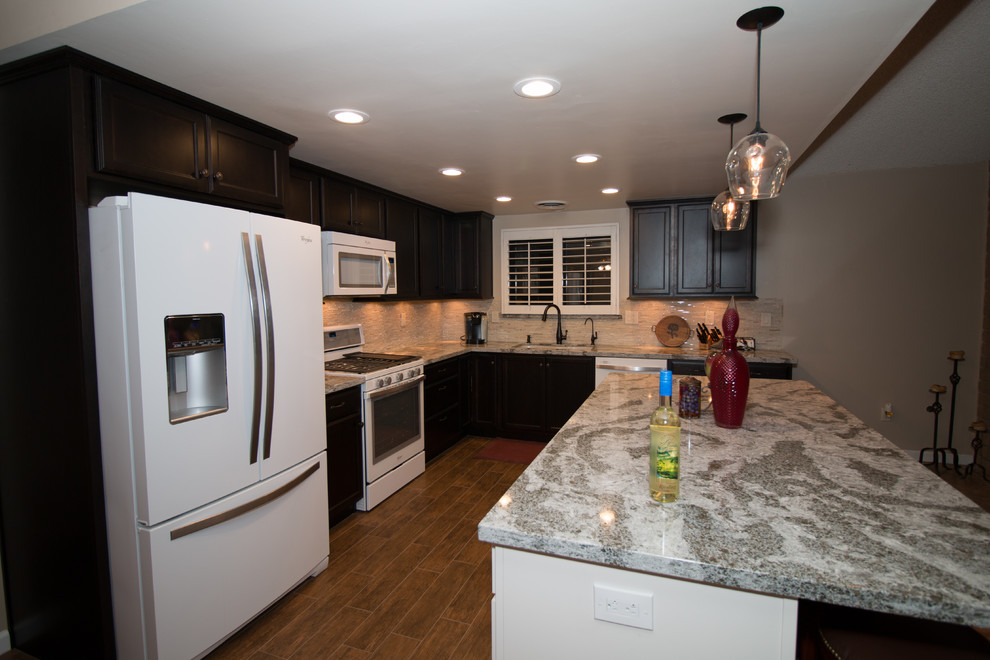 Mid-sized transitional l-shaped porcelain tile open concept kitchen photo with an undermount sink, flat-panel cabinets, dark wood cabinets, quartz countertops, beige backsplash, glass sheet backsplash, white appliances and an island