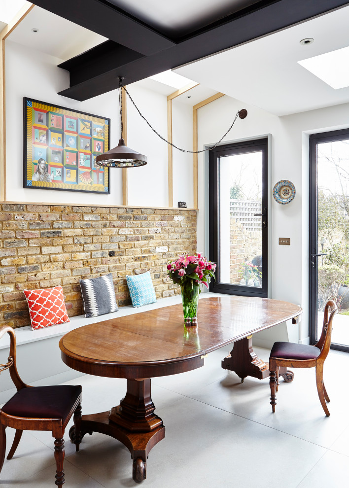 Photo of a bohemian dining room in London with white walls, concrete flooring and grey floors.