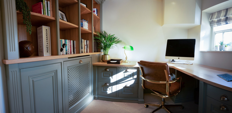 This is an example of a mid-sized traditional study room in West Midlands with grey walls, carpet, a standard fireplace, a plaster fireplace surround, a built-in desk, beige floor, wallpaper and wallpaper.