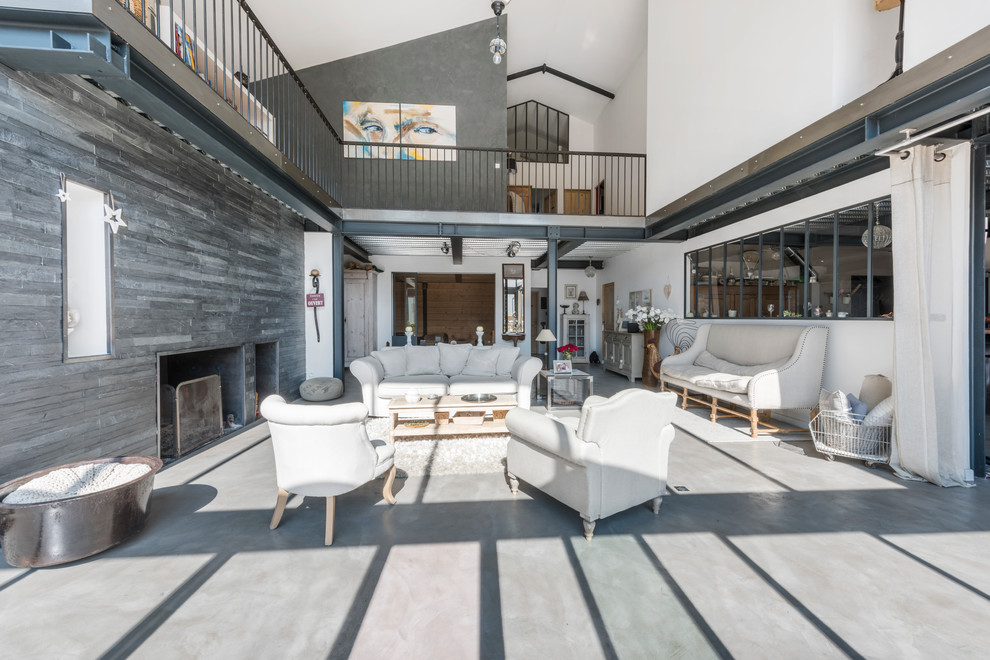This is an example of a large industrial formal open concept living room in Lyon with white walls, concrete floors, a ribbon fireplace and no tv.
