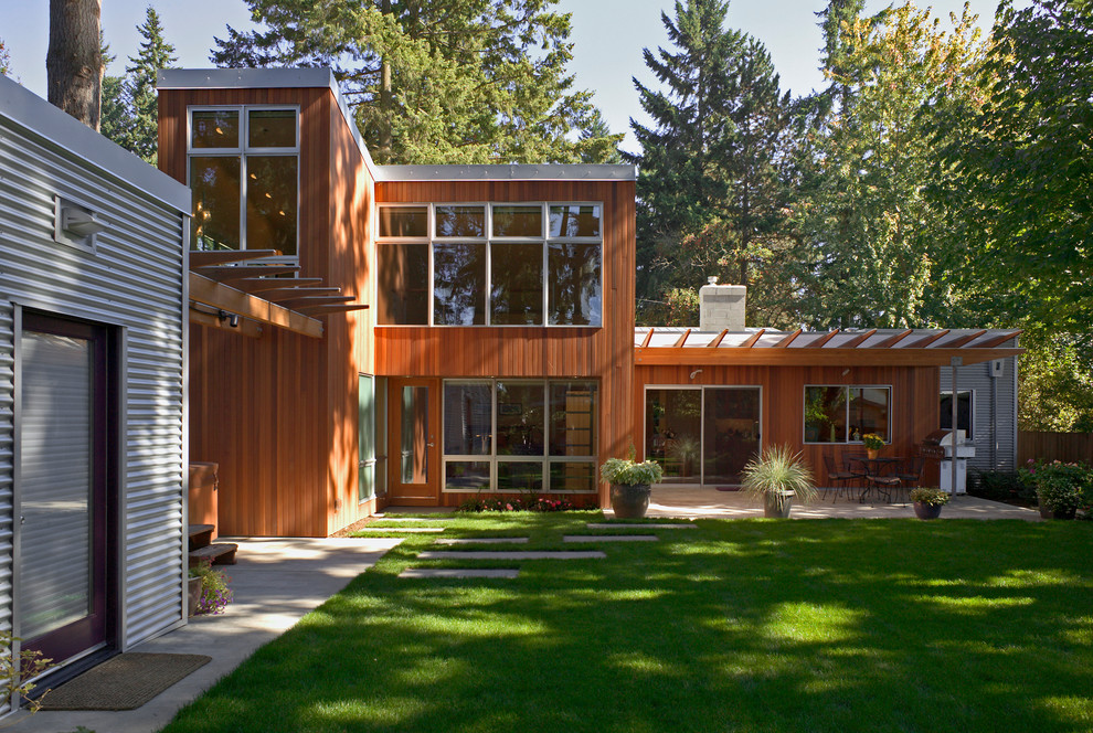This is an example of a contemporary two-storey exterior in Seattle with wood siding and a shed roof.
