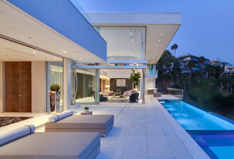 Contemporary backyard rectangular infinity pool in Los Angeles with stamped concrete.