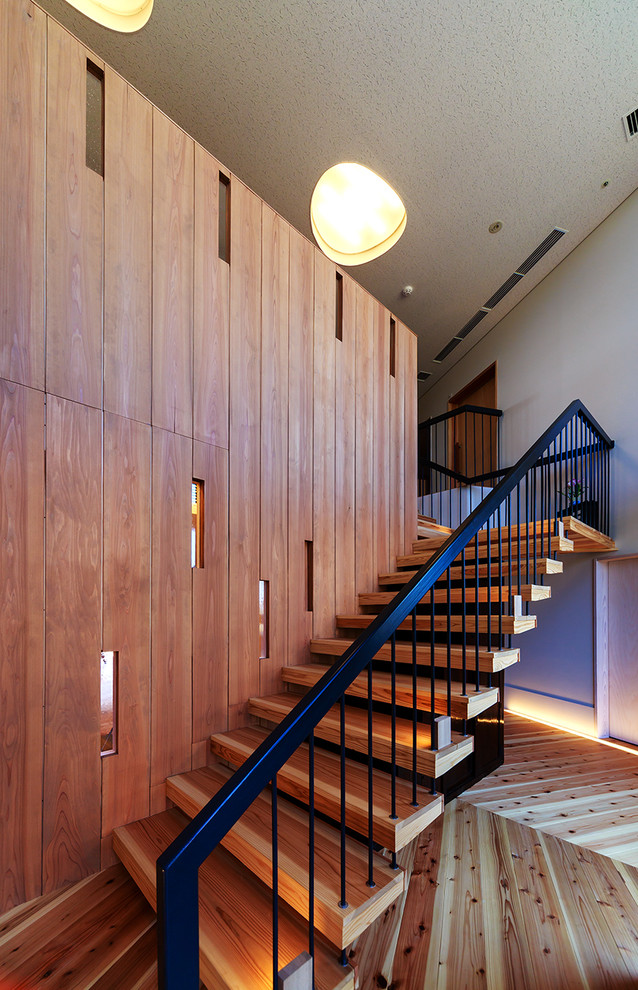 Photo of a mid-sized industrial wood l-shaped staircase in Other with open risers.