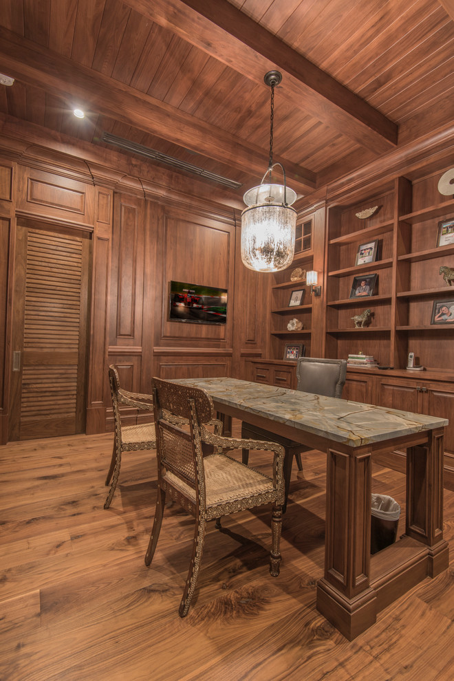 This is an example of a large tropical study room in Tampa with brown walls, light hardwood floors and a freestanding desk.