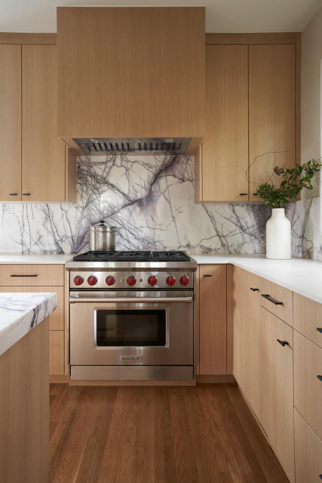 This is an example of a modern kitchen/diner in San Francisco with light wood cabinets, marble worktops, multi-coloured splashback, marble splashback, stainless steel appliances, an island and multicoloured worktops.