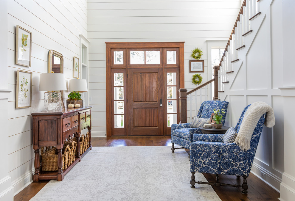 Design ideas for a country entry hall in Jacksonville with white walls, medium hardwood floors, a single front door, a medium wood front door and brown floor.