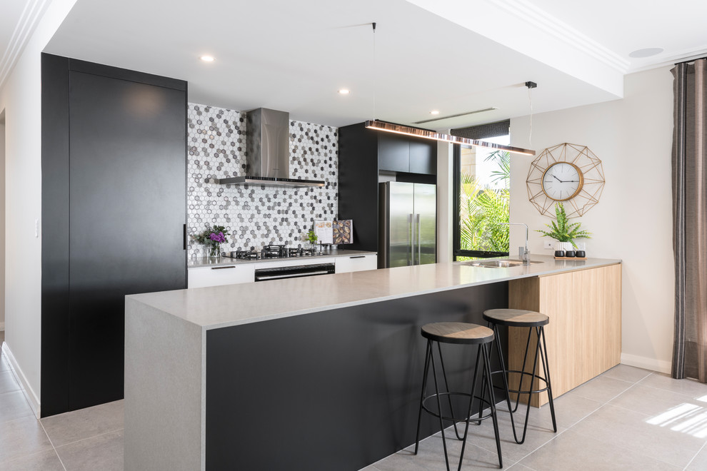 Photo of a mid-sized contemporary galley open plan kitchen in Perth with an undermount sink, flat-panel cabinets, black cabinets, concrete benchtops, black appliances, porcelain floors, grey floor, grey benchtop and multi-coloured splashback.