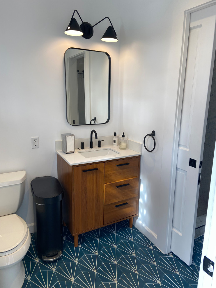Exempel på ett stort retro vit vitt badrum, med släta luckor, skåp i mellenmörkt trä, en dusch i en alkov, en toalettstol med hel cisternkåpa, grå kakel, mosaik, vita väggar, cementgolv, ett nedsänkt handfat, bänkskiva i kvarts, blått golv och dusch med gångjärnsdörr