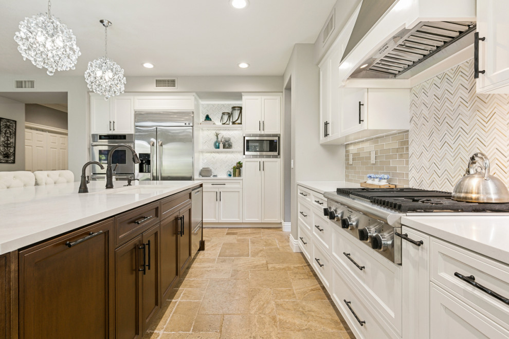 Exempel på ett stort klassiskt vit vitt kök med öppen planlösning, med en undermonterad diskho, skåp i shakerstil, vita skåp, bänkskiva i kvarts, beige stänkskydd, stänkskydd i glaskakel, rostfria vitvaror, travertin golv, en köksö och brunt golv