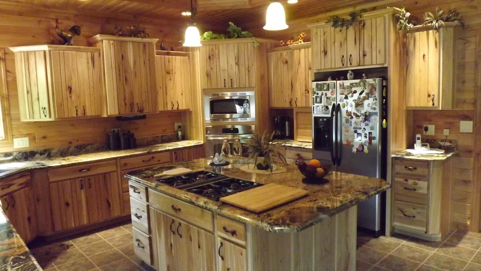 Mountain style u-shaped porcelain tile and brown floor enclosed kitchen photo with an undermount sink, stainless steel appliances and an island