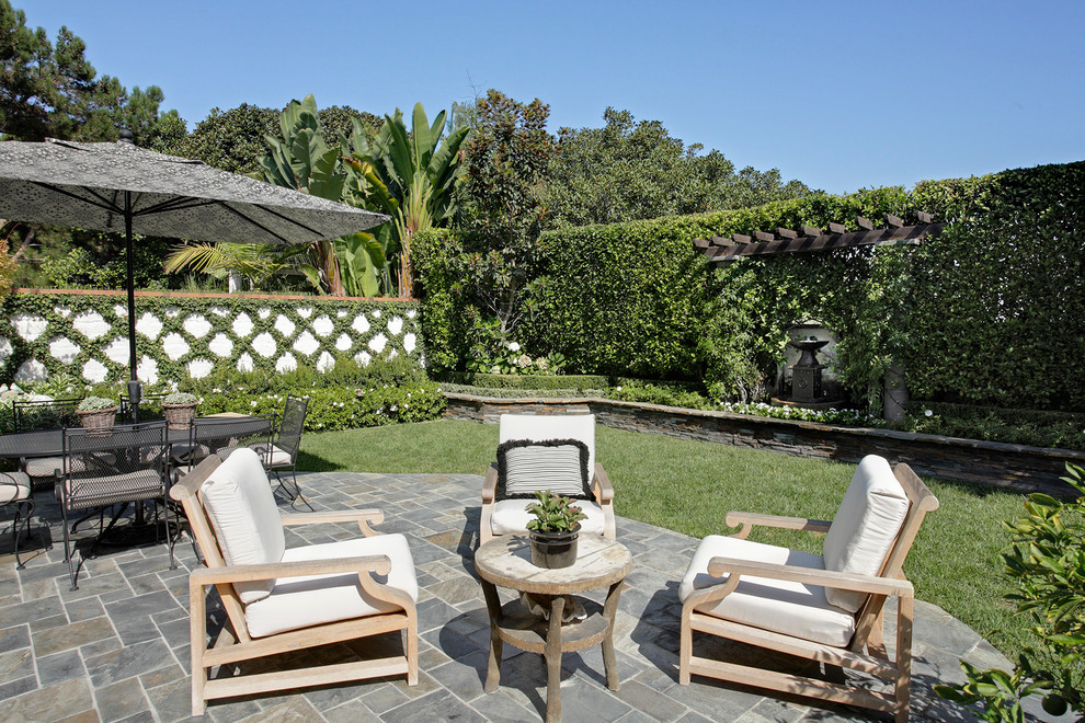 Mid-sized traditional backyard patio in Orange County with a pergola, a water feature and natural stone pavers.