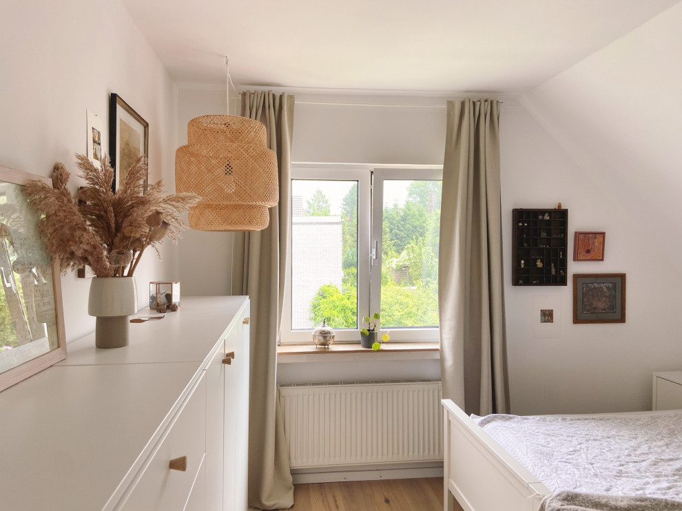 Medium sized scandi master loft bedroom in Dusseldorf with white walls, medium hardwood flooring and brown floors.