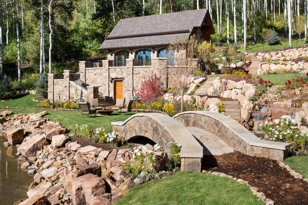 Photo of an expansive country front yard full sun garden for summer in Denver with a garden path and natural stone pavers.