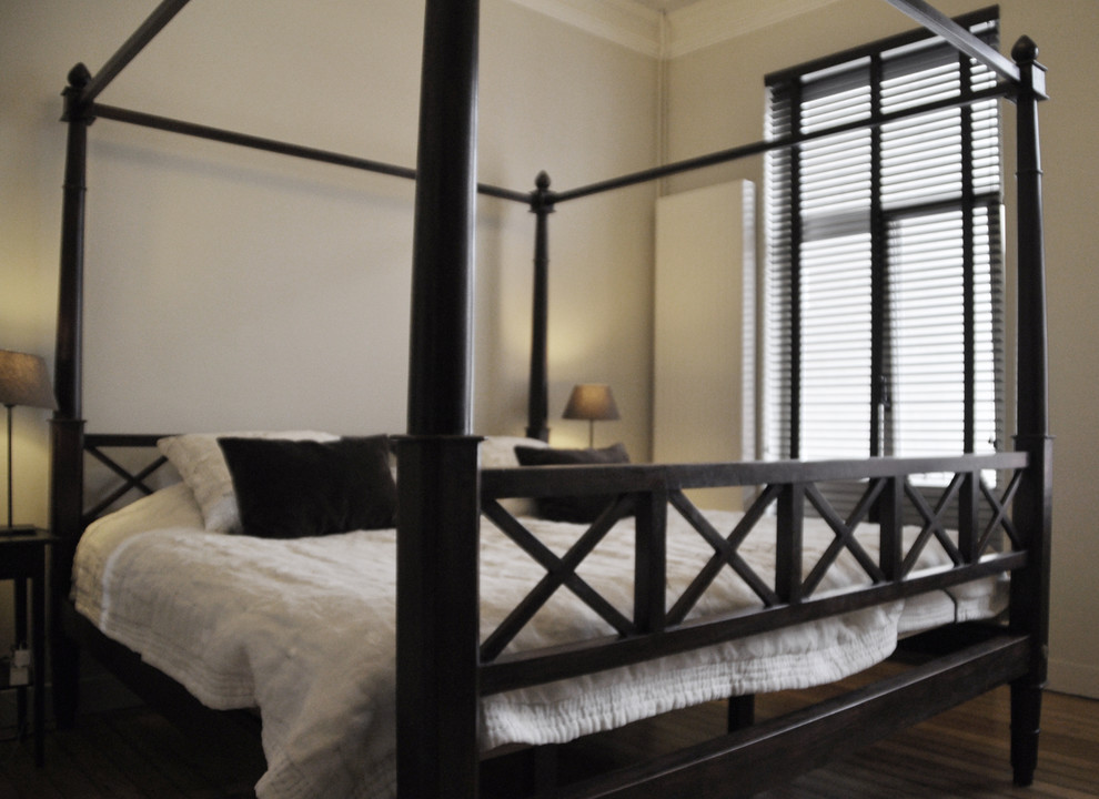 Immagine di una camera da letto etnica con pareti beige e parquet chiaro