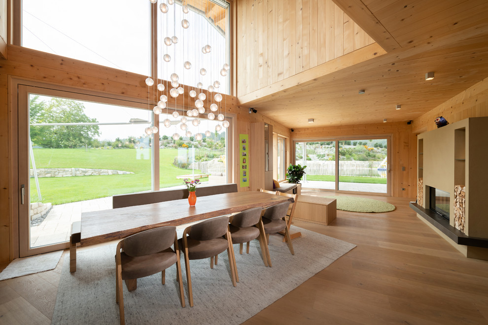 Inspiration pour une grande salle à manger design avec parquet clair, un sol beige, un mur beige et une cheminée standard.