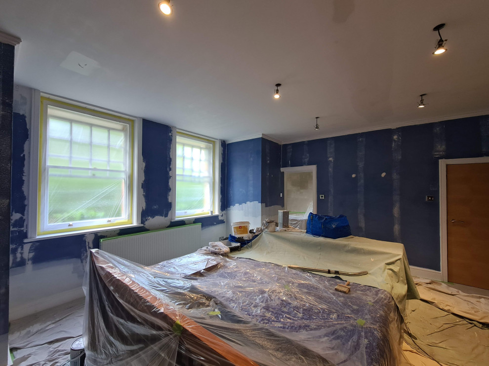 Пример оригинального дизайна: огромная хозяйская спальня: освещение в классическом стиле с синими стенами, ковровым покрытием, бежевым полом и многоуровневым потолком