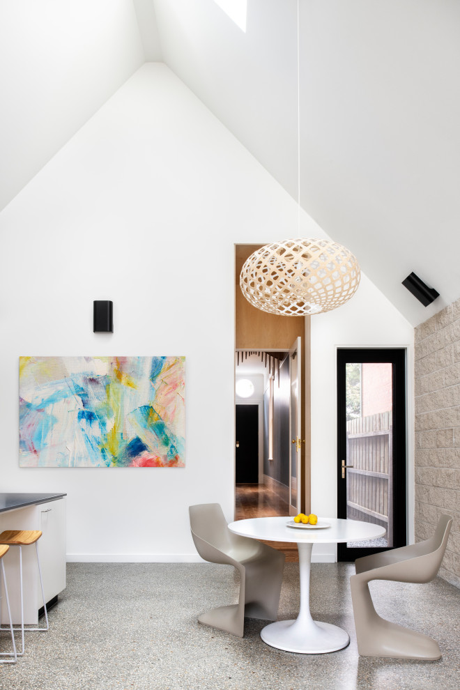 Photo of a contemporary dining room in Melbourne with white walls, grey floor and vaulted.