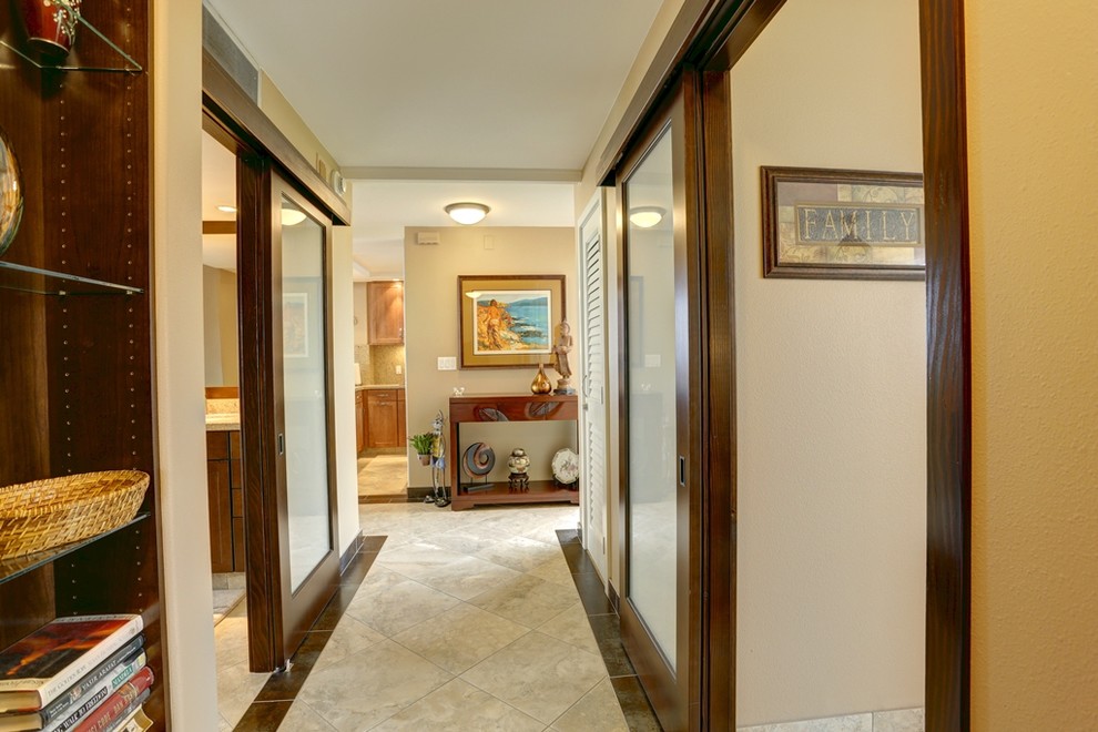This is an example of a large tropical hallway in Hawaii with beige walls and porcelain floors.
