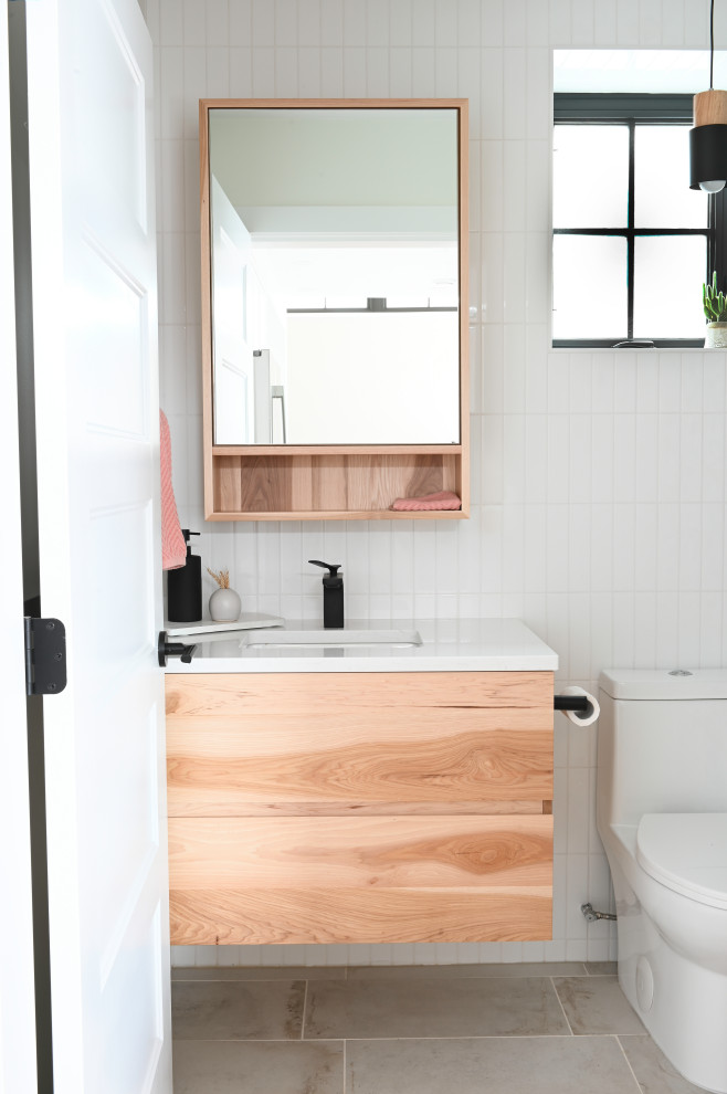 Design ideas for a small contemporary kids bathroom in Vancouver with light hardwood floors, beige floor, flat-panel cabinets, light wood cabinets, an alcove tub, a shower/bathtub combo, a two-piece toilet, white tile, ceramic tile, white walls, an undermount sink, engineered quartz benchtops, a shower curtain, white benchtops, a single vanity and a floating vanity.