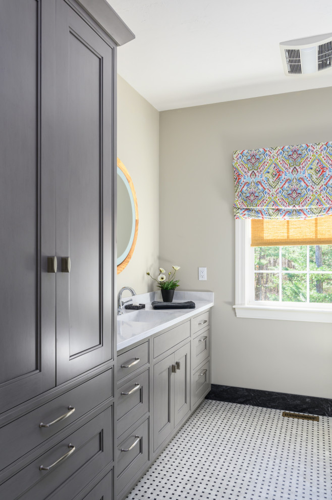 Photo of a medium sized contemporary ensuite bathroom in Boston with beaded cabinets, grey cabinets, a walk-in shower, a one-piece toilet, beige walls, ceramic flooring, an integrated sink, solid surface worktops, multi-coloured floors, an open shower, white worktops, a single sink and a built in vanity unit.