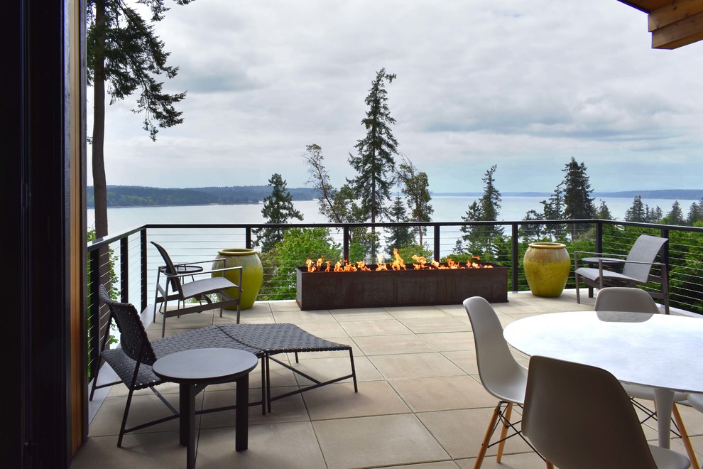 Photo of a contemporary backyard deck in Seattle with a fire feature and no cover.