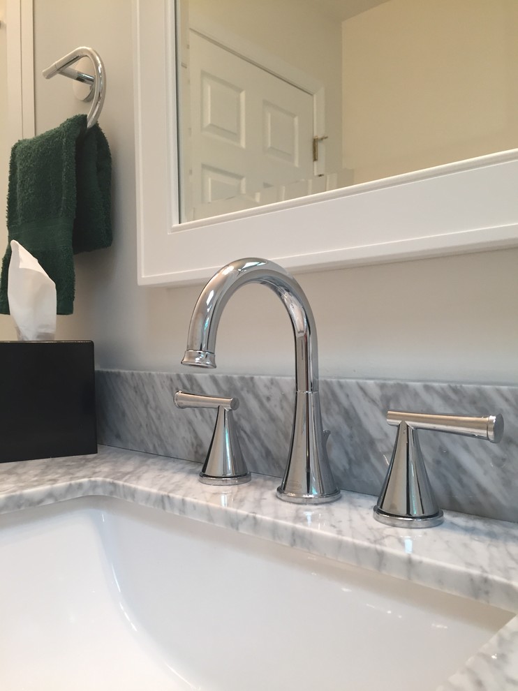 Home design - mid-sized transitional gray tile and porcelain tile porcelain tile home design idea in Indianapolis with flat-panel cabinets, white cabinets, a one-piece toilet, white walls, an undermount sink and marble countertops