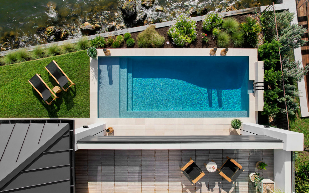 Идея дизайна: маленький прямоугольный бассейн на заднем дворе в стиле модернизм с фонтаном для на участке и в саду