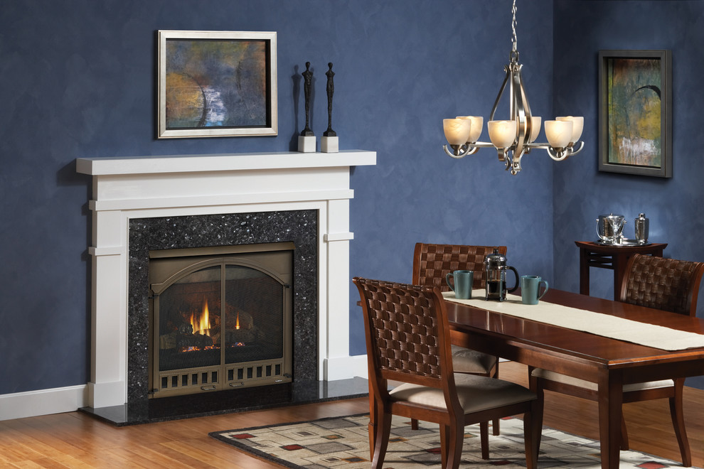 Mid-sized transitional separate dining room in Boston with blue walls, medium hardwood floors, a standard fireplace, a tile fireplace surround and brown floor.
