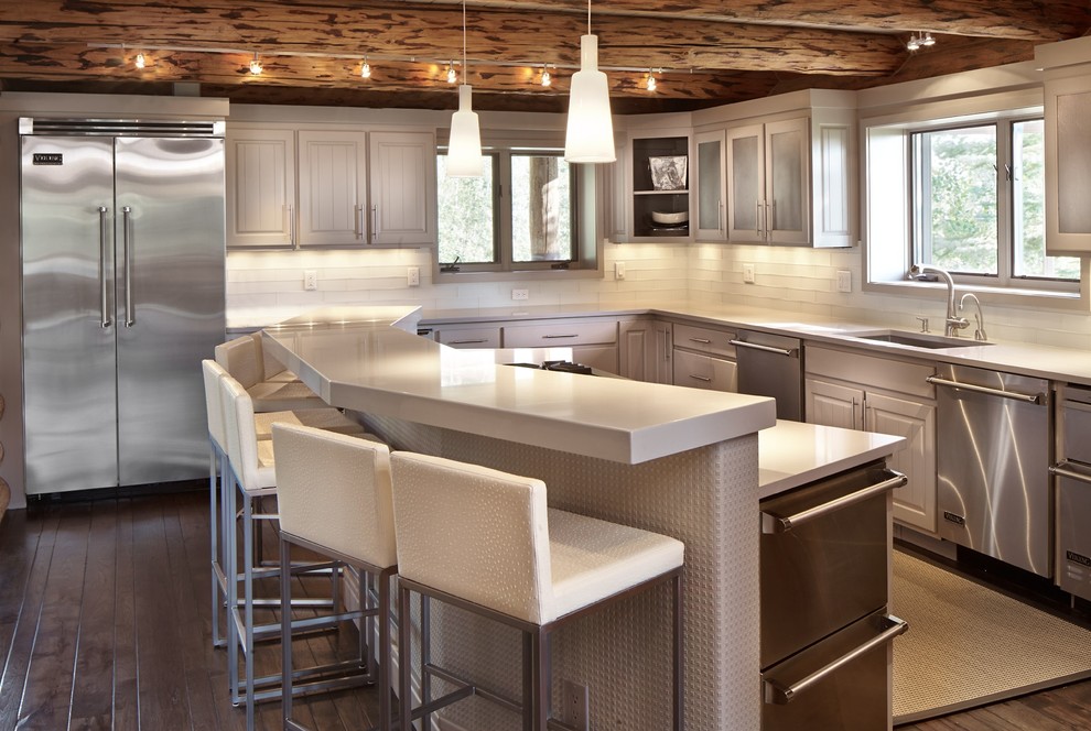 This is an example of a country l-shaped kitchen in Denver with an undermount sink, grey cabinets, white splashback, stainless steel appliances, dark hardwood floors and with island.