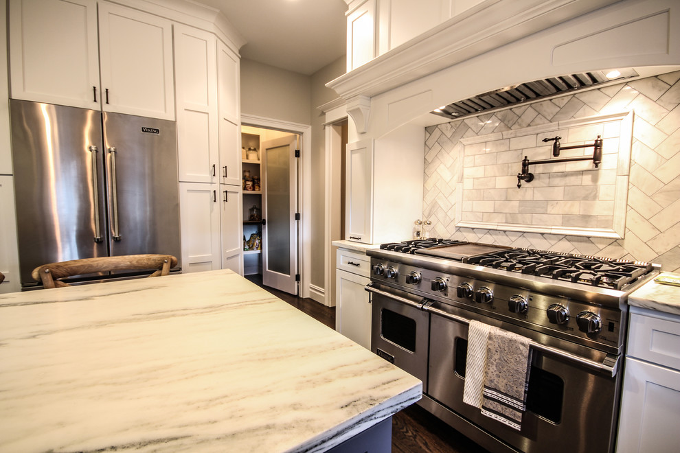 Eat-in kitchen - transitional eat-in kitchen idea in Detroit with a farmhouse sink, shaker cabinets, white cabinets, marble countertops, gray backsplash, subway tile backsplash and stainless steel appliances