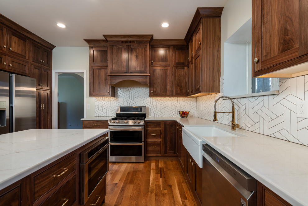 Mid-sized transitional u-shaped medium tone wood floor eat-in kitchen photo with a farmhouse sink, beaded inset cabinets, medium tone wood cabinets, white backsplash, stainless steel appliances and an island
