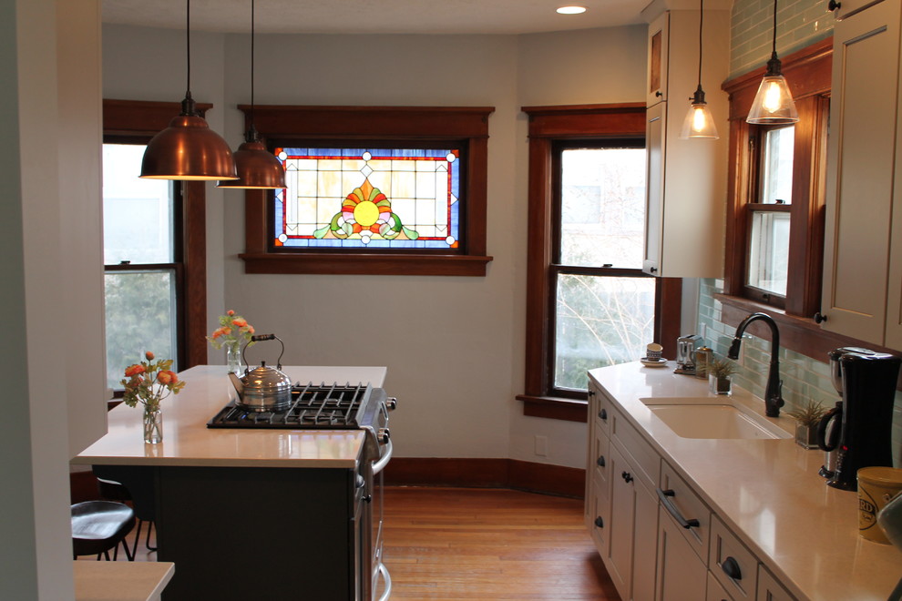 Kitchen - mid-sized transitional medium tone wood floor kitchen idea with an undermount sink, shaker cabinets, white cabinets, quartz countertops, blue backsplash, subway tile backsplash and an island