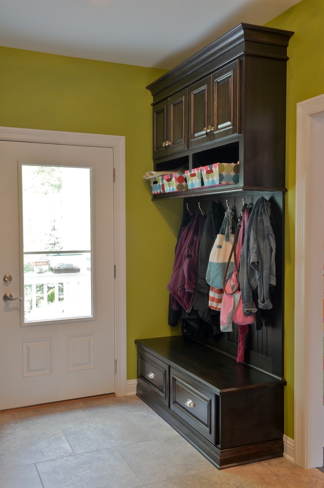 Inspiration for a mid-sized traditional mudroom in Milwaukee with green walls and ceramic floors.