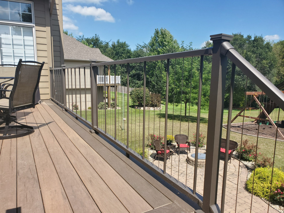 Example of a mid-sized backyard second story cable railing deck design with no cover