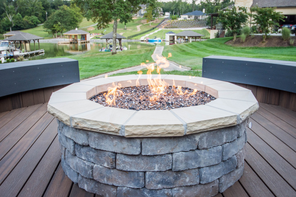 Example of a large transitional backyard deck design with a fire pit and no cover