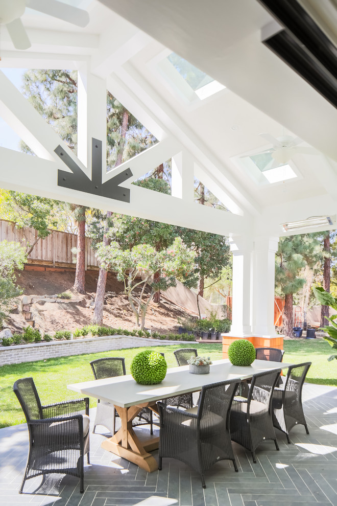 Photo of a transitional backyard patio in Orange County with a roof extension.