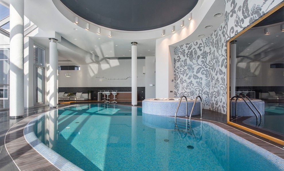 Contemporary indoor custom-shaped pool in Other with a hot tub.