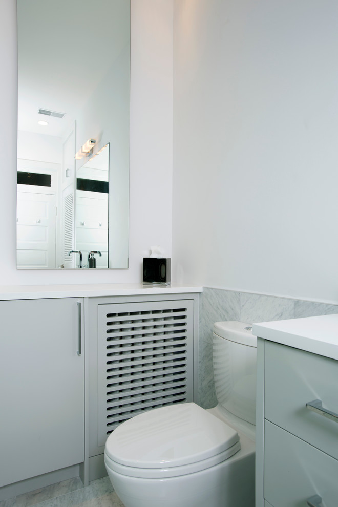 This is an example of a mid-sized contemporary master bathroom in DC Metro with flat-panel cabinets, grey cabinets, an alcove tub, an alcove shower, a one-piece toilet, black tile, gray tile, white tile, stone tile, white walls, marble floors, an undermount sink and solid surface benchtops.